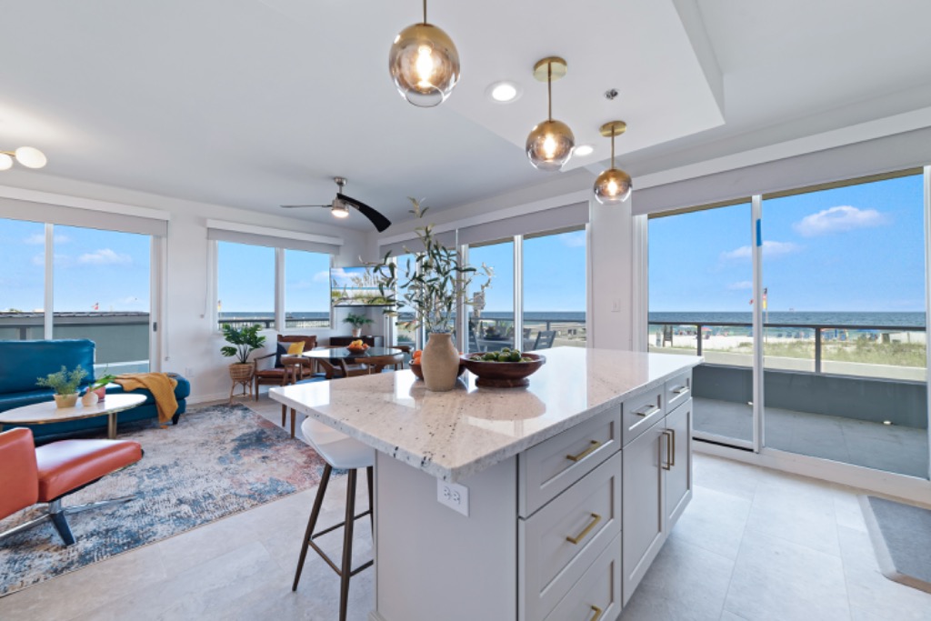 Open kitchen and living room of the Silver Beach Orange Beach condo looking through floor-to-ceiling sliders to the Gulf of Mexico