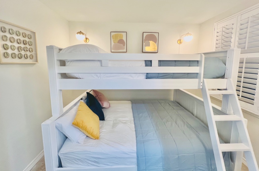Bunk room with twin-over-full bunk bed, plantation shutters, and built-in ladder